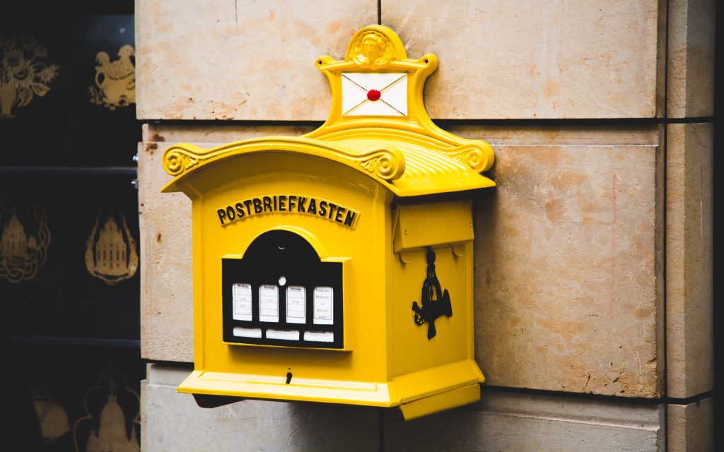 yellow-postbriefkasten-floating-mailbox-on-brown-concrete-217250
